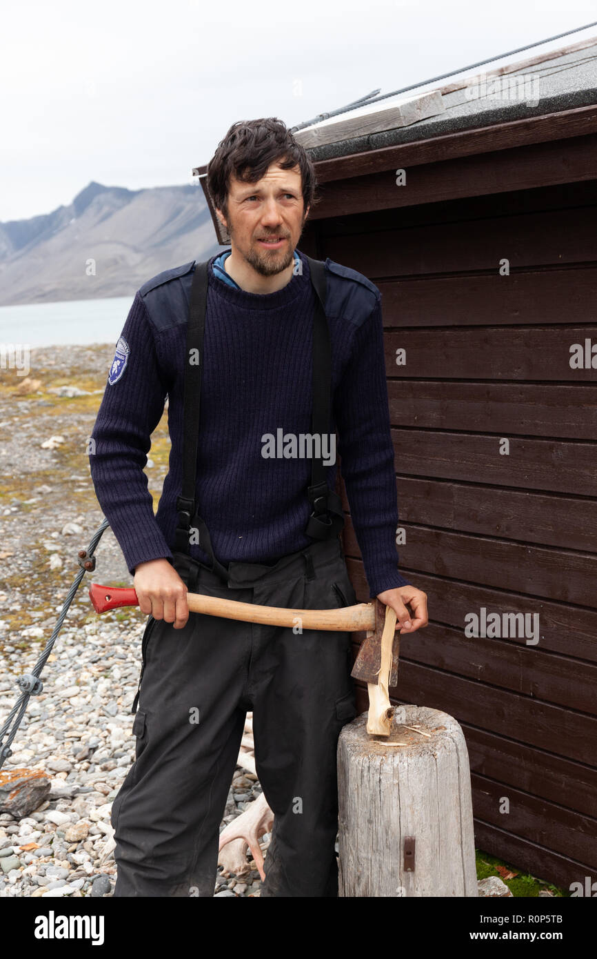 Ein Polizeioffizier hackt Holz außerhalb seiner isolierten Station als Teil seines Jobs die remote Isfjorden in Svalbard, in der Arktis zu schützen. Stockfoto