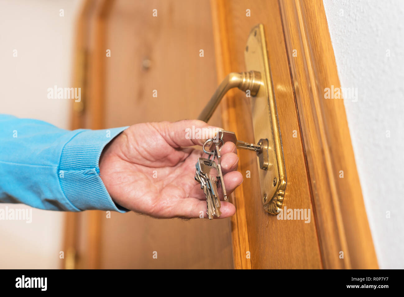 Älterer Mann oben Verriegelung Tür mit Schlüssel in der Hand Stockfoto