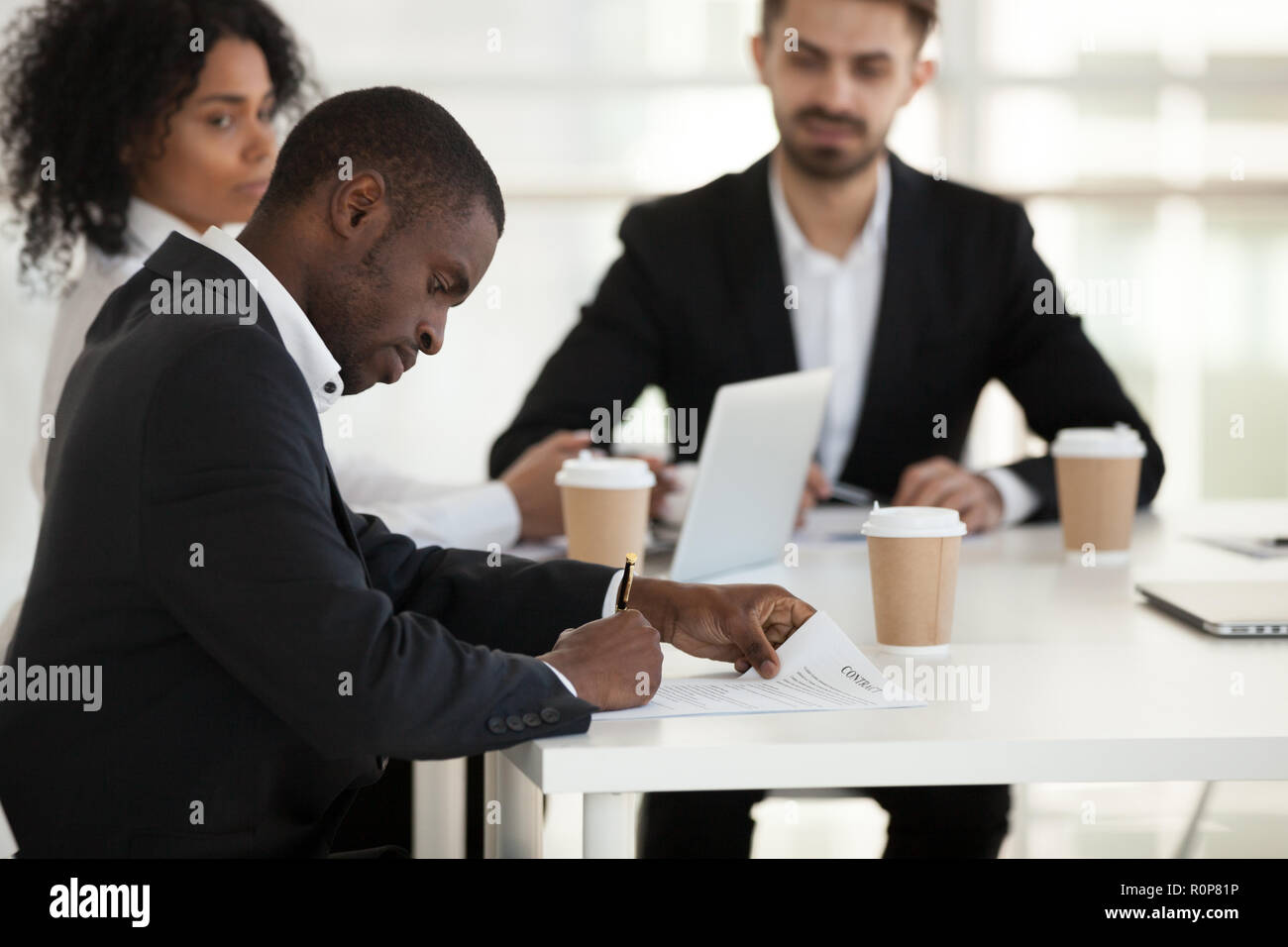 Afrikanische amerikanische Mitarbeiter unterzeichnen Vertrag in der Sitzung Stockfoto