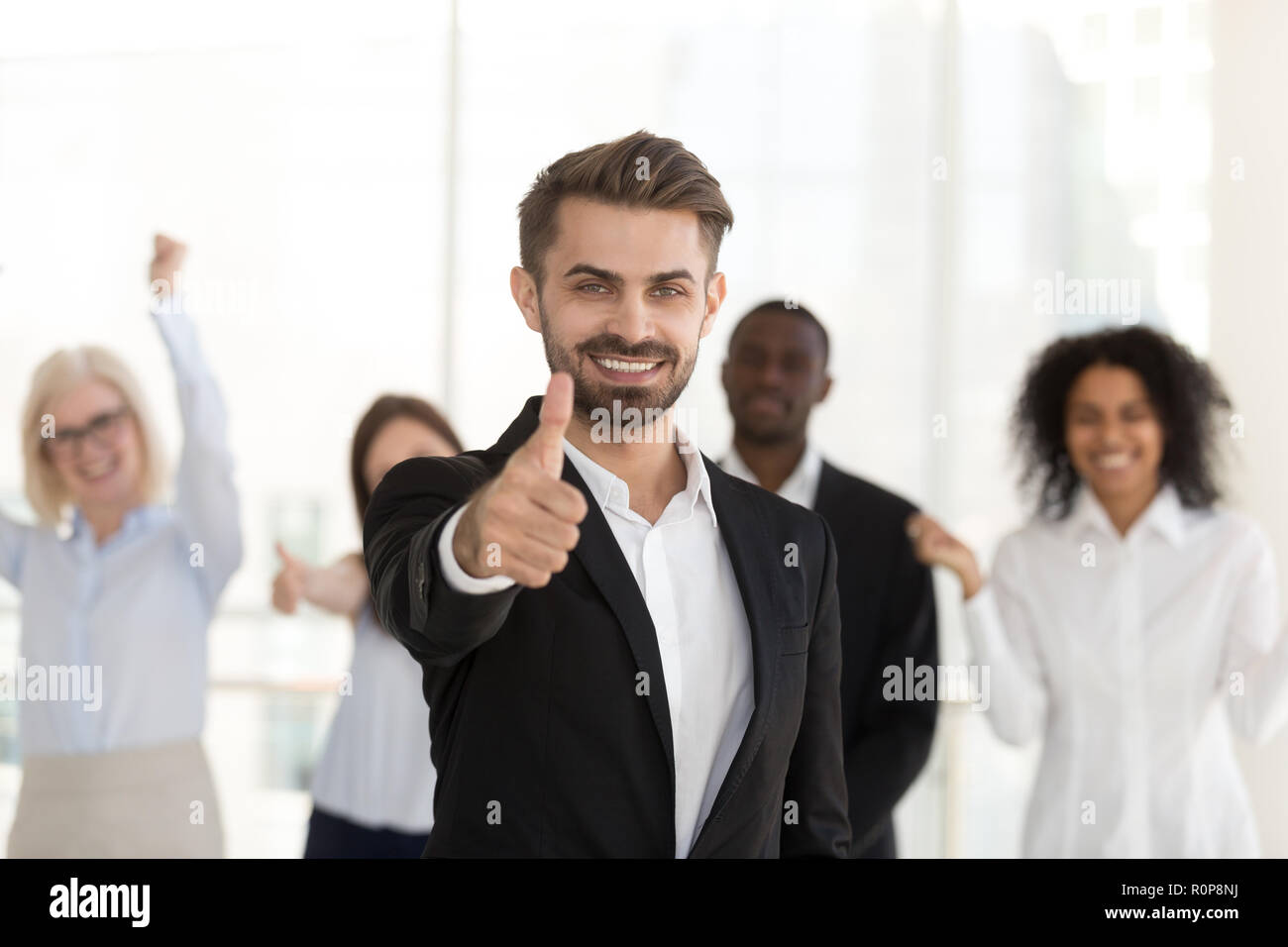 Aufgeregt, männliche Mitarbeiter zeigen Daumen hoch zufrieden mit der Firma Stockfoto