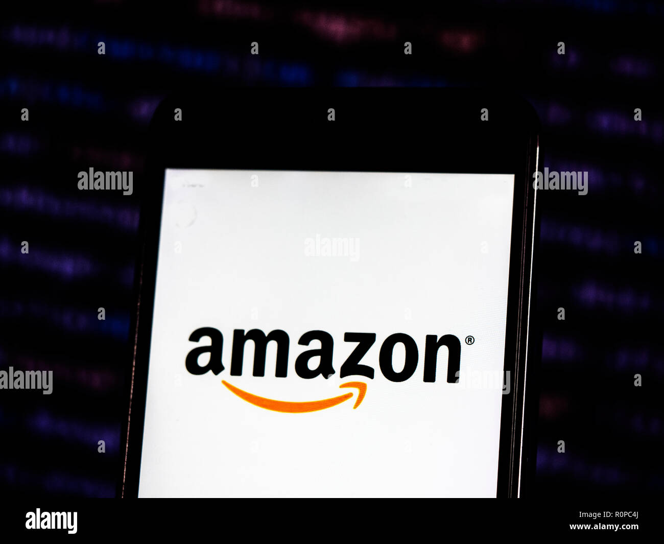 Das Amazon-Logo gesehen auf einem Smartphone mit dem Hintergrund einer Börse shedle angezeigt. Amazon.com, Inc., das als Amazon, ist eine US-amerikanische Electronic Commerce und Cloud Computing company in Seattle, Washington. Stockfoto