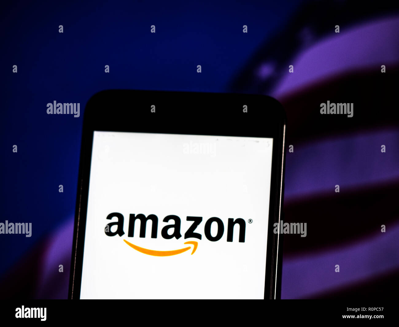 Das Amazon-Logo gesehen auf einem Smartphone mit dem Hintergrund einer Börse shedle angezeigt. Amazon.com, Inc., das als Amazon, ist eine US-amerikanische Electronic Commerce und Cloud Computing company in Seattle, Washington. Stockfoto