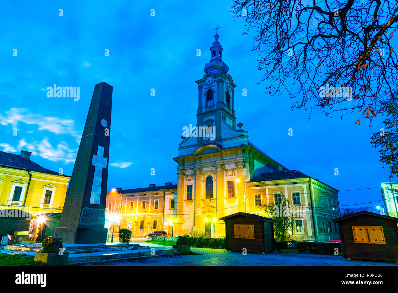 Nachtaufnahme der Reformierten Kirche und zentralen Kreuz Denkmal der Stadt, in Baia Mare, Rumänien Stockfoto