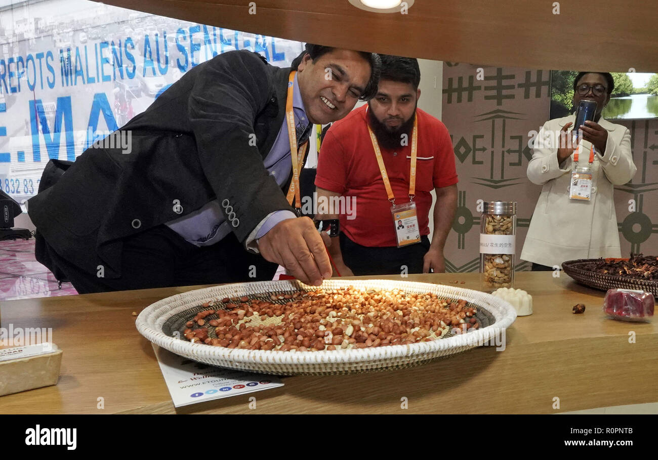 Shanghai, China. 6 Nov, 2018. Besucher geschmack Erdnüsse auf dem Stand des Senegal bei der ersten China International Import Expo (CIIE) in Shanghai, China, November 6, 2018. Insgesamt 82 Staaten und drei internationalen Organisationen stellten ihre Leistungen in der Entwicklung von Wirtschaft und Handel sowie wettbewerbsfähige Produkte an 71 Ständen im Land Pavillon für Handel und Investitionen an der Ciie. Credit: Shen Bohan/Xinhua/Alamy leben Nachrichten Stockfoto