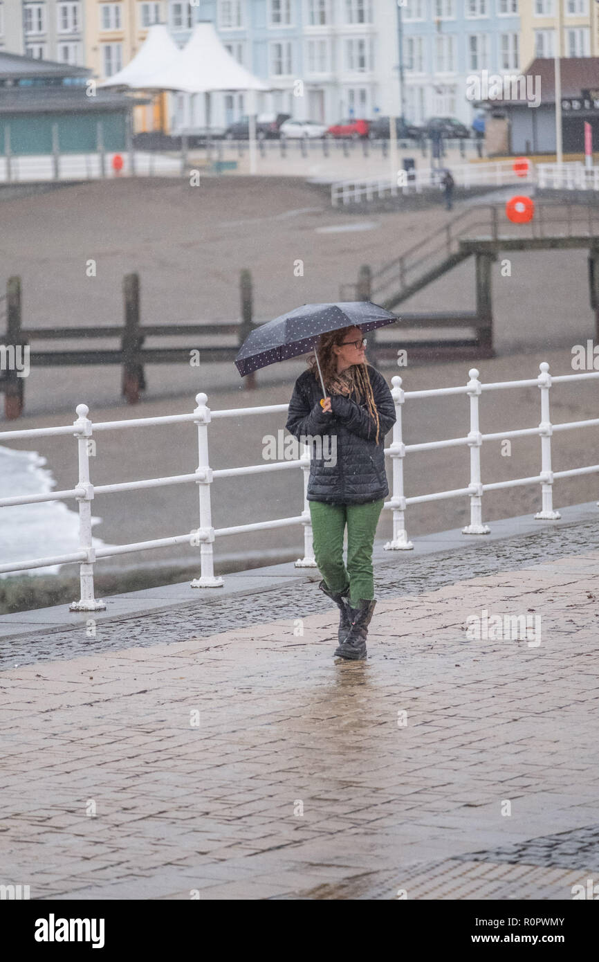 Aberystwyth, Wales, UK. 7. November 2018. UK Wetter: Menschen zu Fuß im Regen auf einer sehr nass, aber mild, morgen in Aberystwyth. Das Met Office hat eine gelbe Warnmeldung für Regen und Überschwemmungen, die viel von Süd und West Wales heute morgen, mit einer weiteren Warnung für mehr Regen und Sturm Winde für den gleichen Bereich am Freitag gab auch ausgestellt. Foto: Keith Morris/Alamy leben Nachrichten Stockfoto