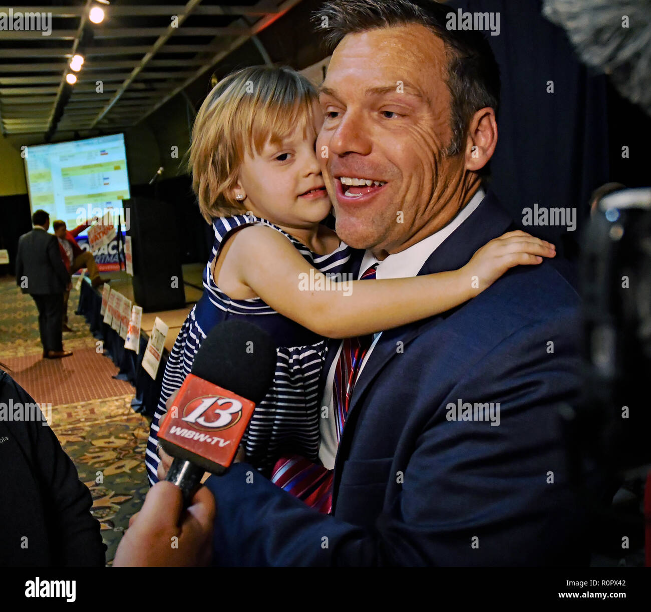 Topeka Kansas, USA, November 6, 2018 Kansas Staatssekretär Kris Kobach hält seine jüngste Tochter, während im Gespräch mit den Medien nach Beendigung seiner Konzession Ausführungen heute abend Credit: Mark Reinstein/MediaPunch Stockfoto