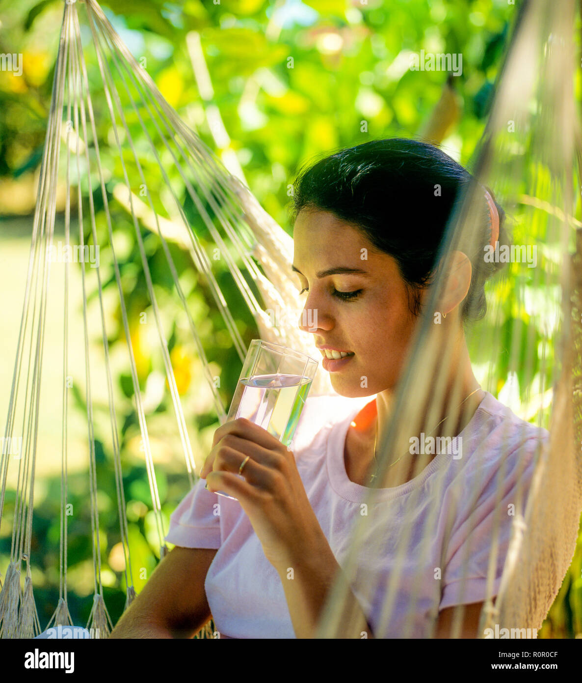 Junge Frau mit einem Glas Wasser, tropischen Garten, Guadeloupe, Französisch Westindien, Stockfoto