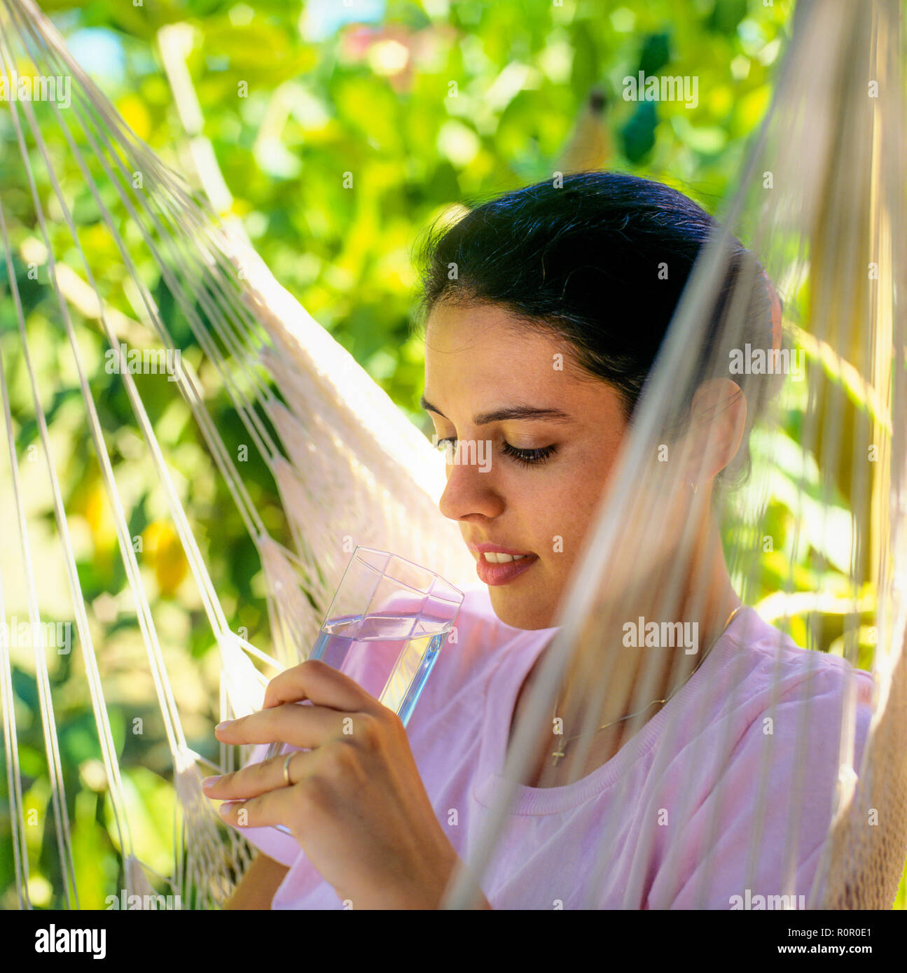 Junge Frau mit einem Glas Wasser, tropischen Garten, Guadeloupe, Französisch Westindien, Stockfoto