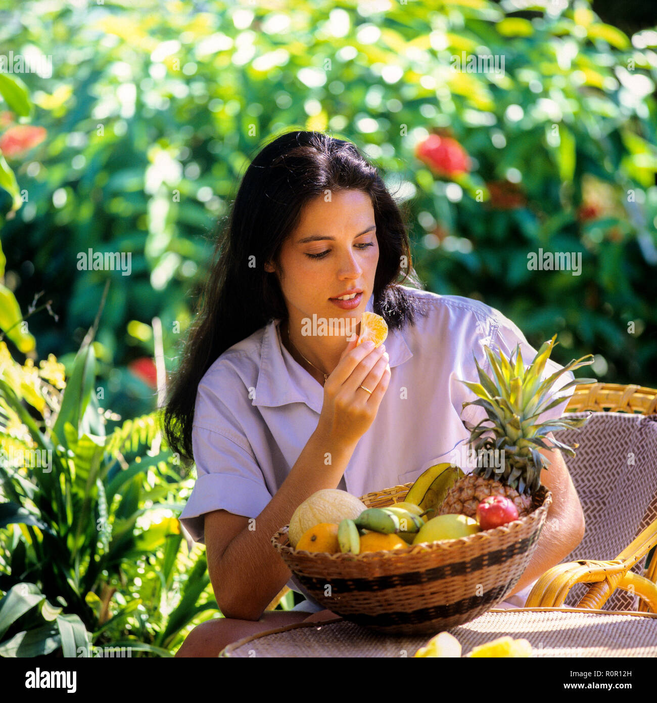 Junge Frau, die exotische Früchte im tropischen Garten, Guadeloupe, Französisch-Westindien isst, eine fittige Frau, die Früchte isst Stockfoto
