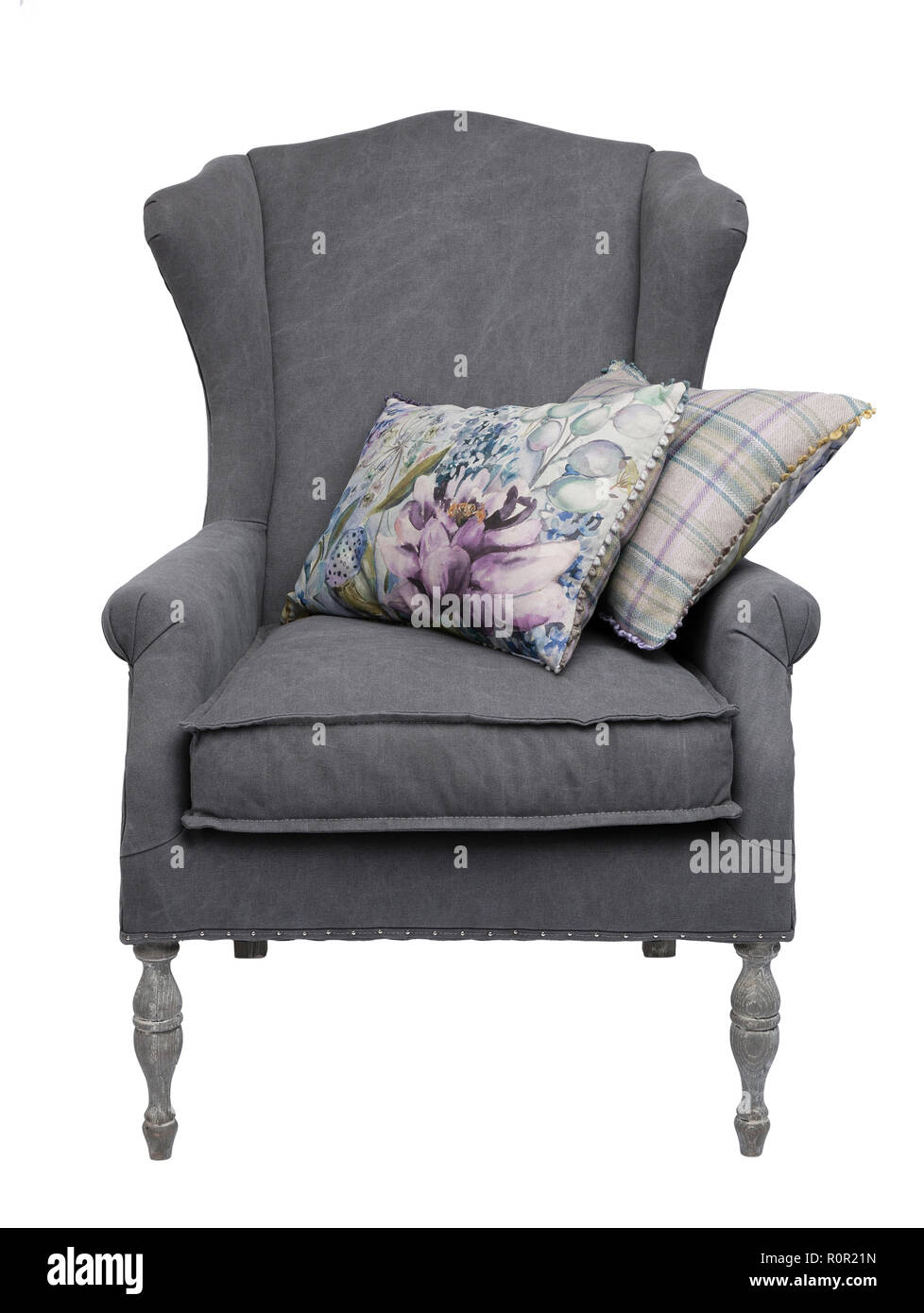 Traditionelle grau Sessel mit floralen und karierten Kissen, auf einem weißen Hintergrund. Stockfoto