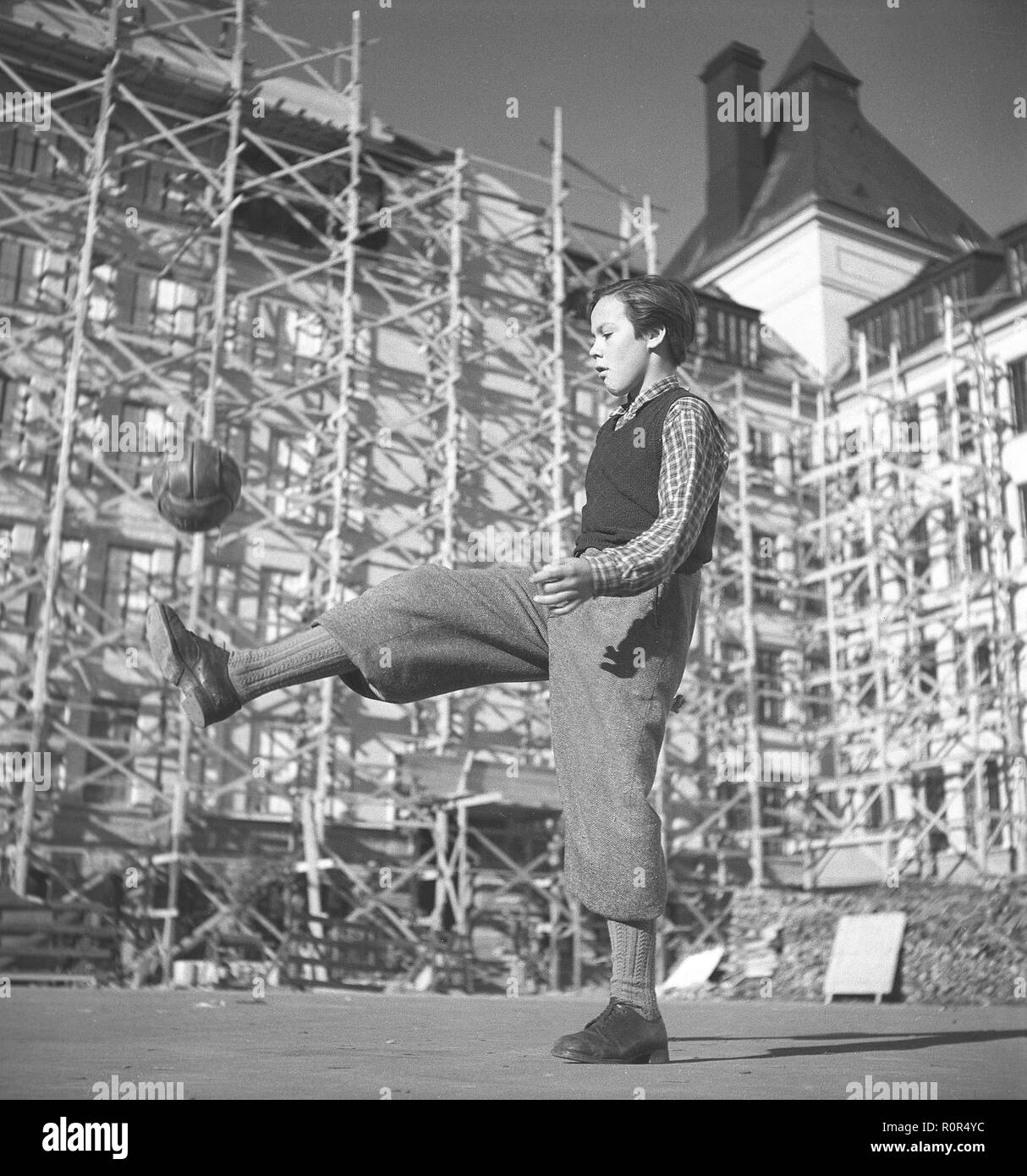 1940er Jahre Jungen Fußball spielen. Ein Junge in typischen 1940