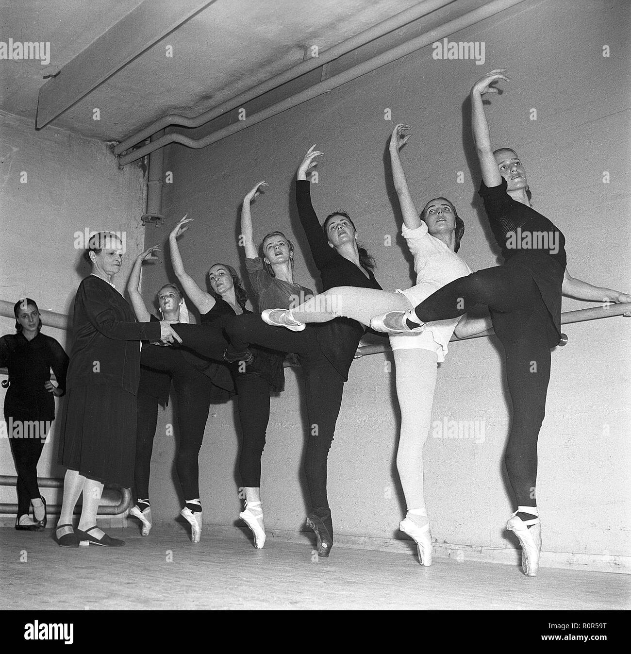 Ballett Schule in den 1940er Jahren. Junge Tänzerinnen üben ihre Ballett in einem Ballett Studio und ein Lehrer ist fest der Anpassung ihrer Positionen, sie recht zu erhalten. Schweden 1947. Foto Kristoffersson ref AE 3-4 Stockfoto