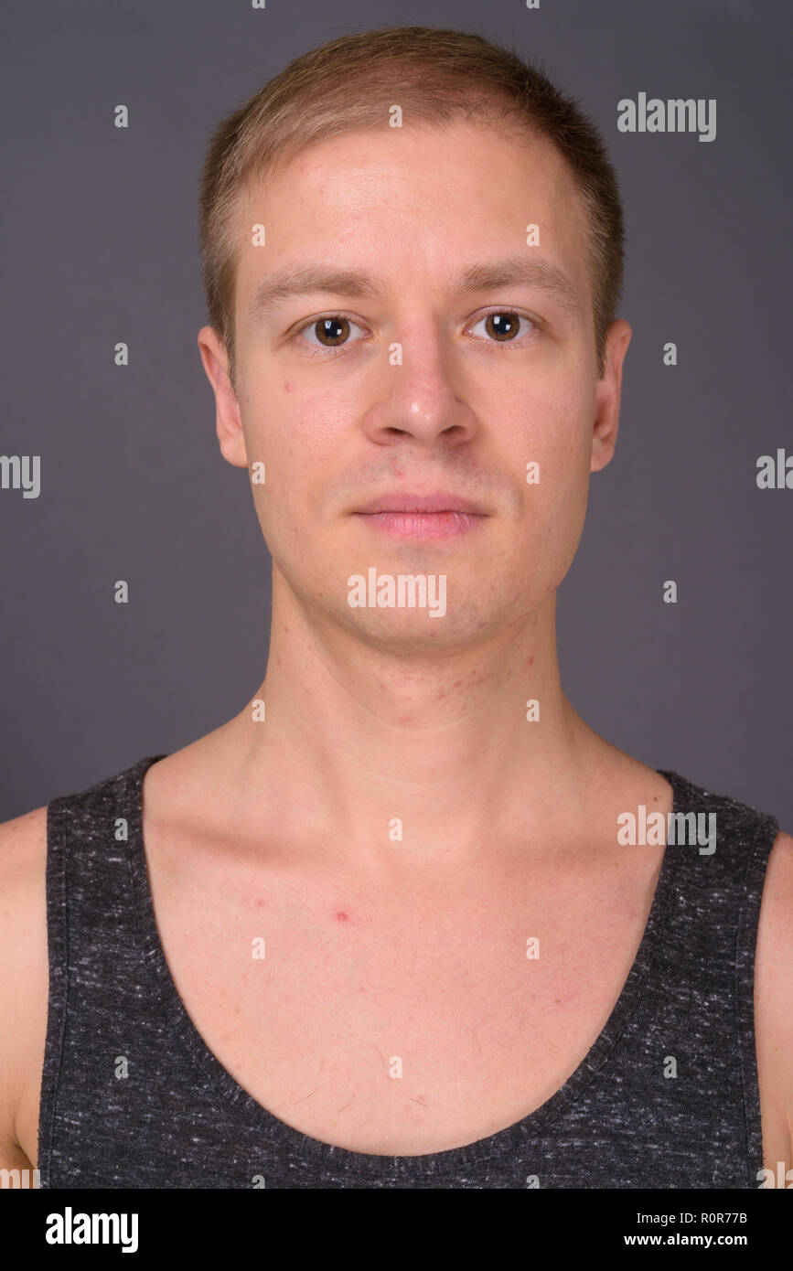 Porträt der jungen gutaussehenden Mann gegen grauer Hintergrund Stockfoto