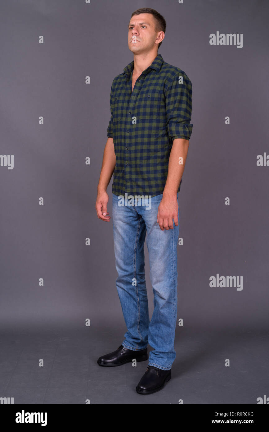 Stattlicher Mann mit kurzen Haaren gegen grauer Hintergrund Stockfoto