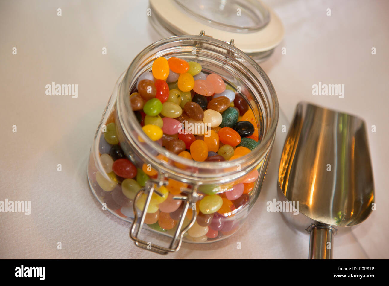 Jelly Beans in einem kilner Glas auf einem Tisch bei einer Hochzeit warten auf die Gäste und essen Sie zu graben Stockfoto
