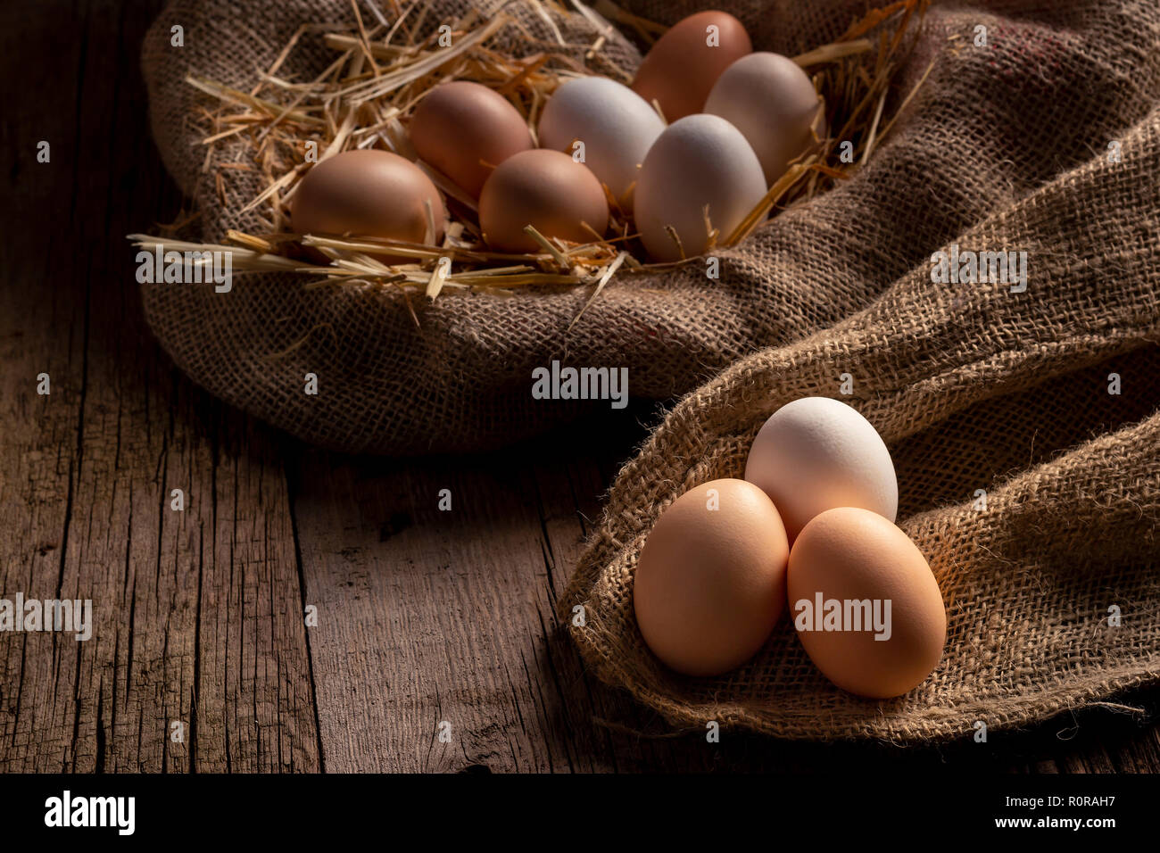 Frische Hühnereier in Farm liegen auf Leinwand auf Holz- Tabelle Stockfoto