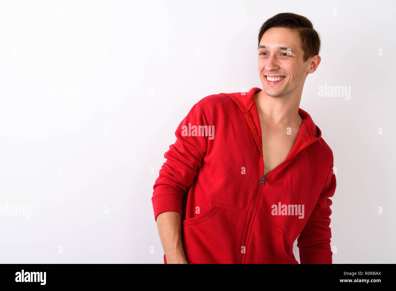 Studio shot der glücklichen jungen gutaussehenden Mann lächelnd, während Sie zu Stockfoto