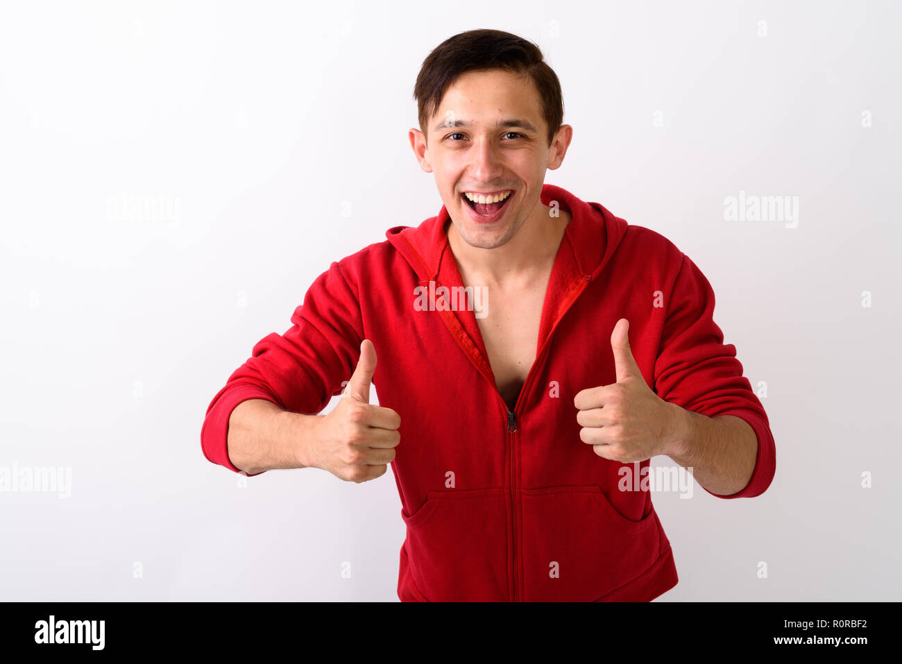 Studio shot der glücklichen jungen gutaussehenden Mann lächelnd, während Sie do Stockfoto