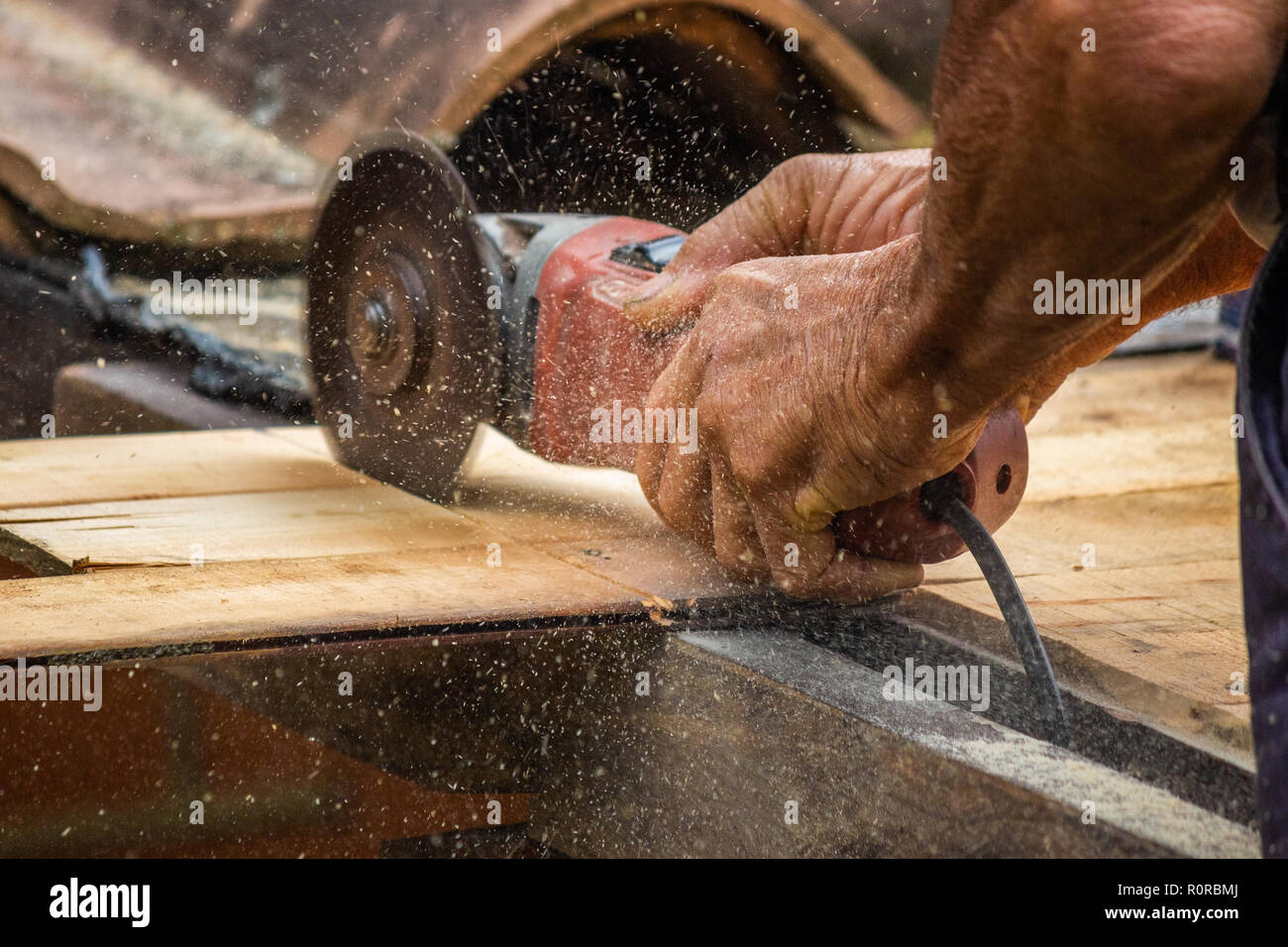 Ein Tischler Mann schneiden ein Stück Holz für Dacharbeiten Stockfoto