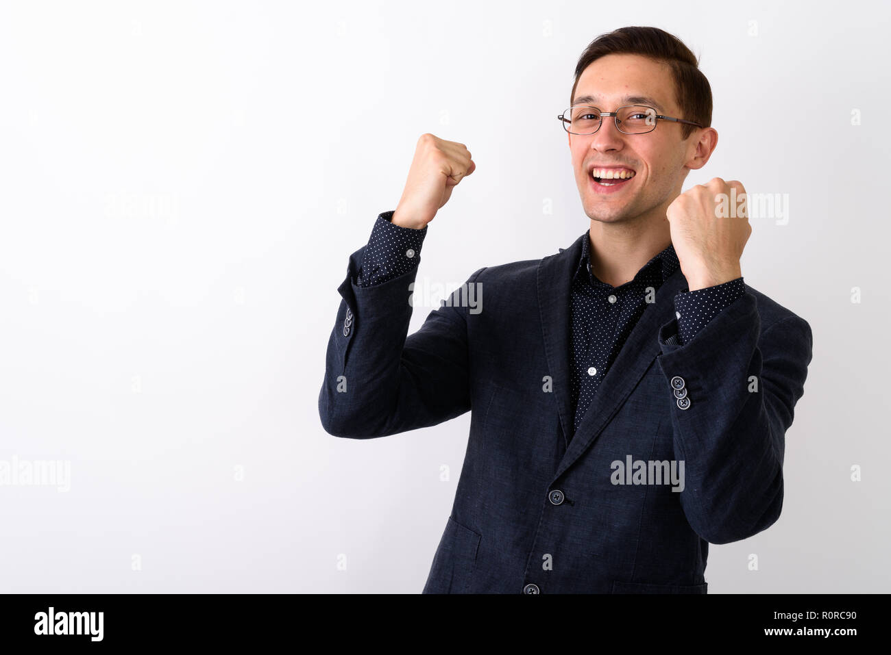 Studio shot junger Geschäftsmann glücklich lächelnd und suchen Erregung Stockfoto