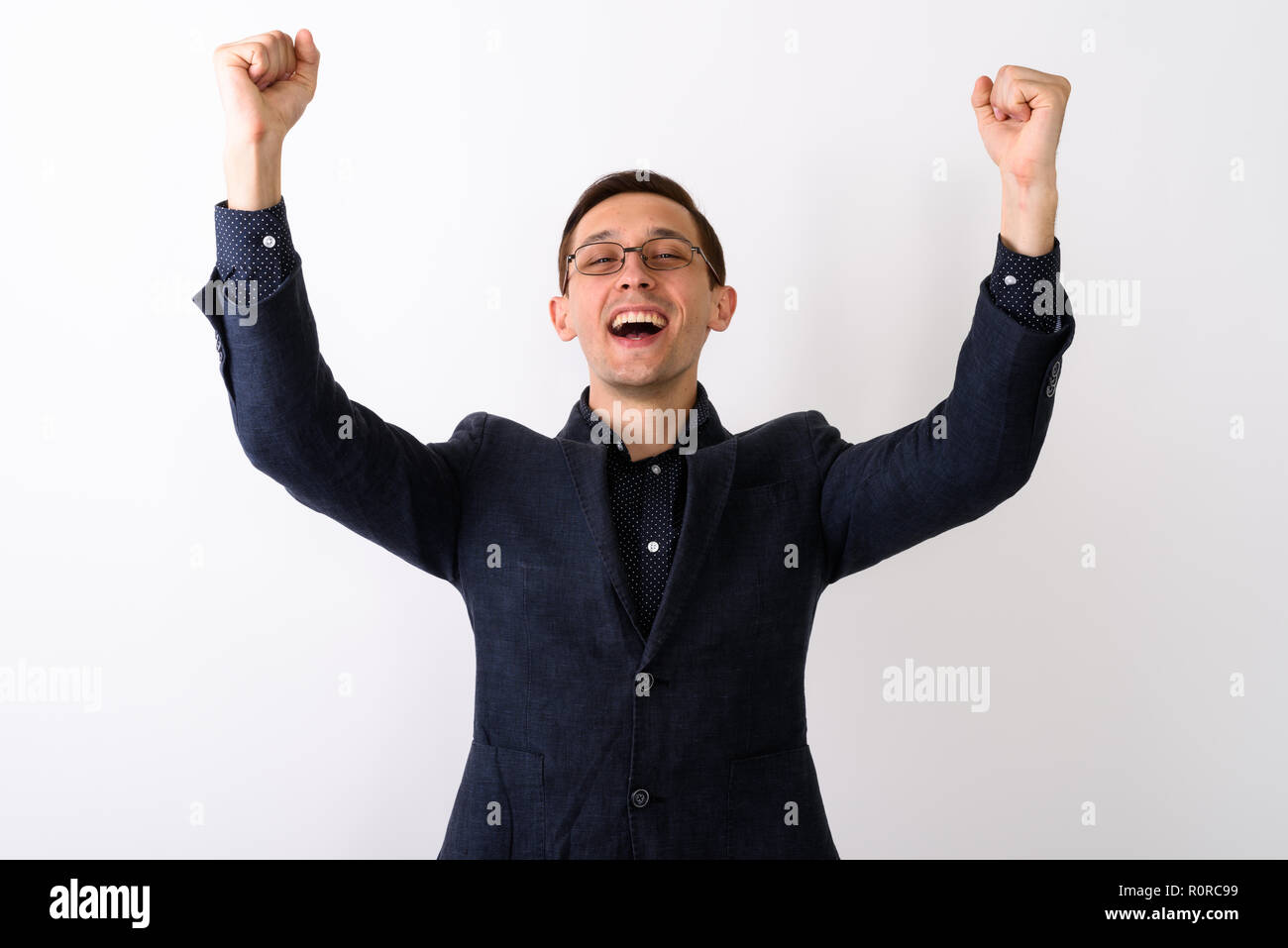 Studio shot junger Geschäftsmann glücklich lächelnd und suchen Erregung Stockfoto