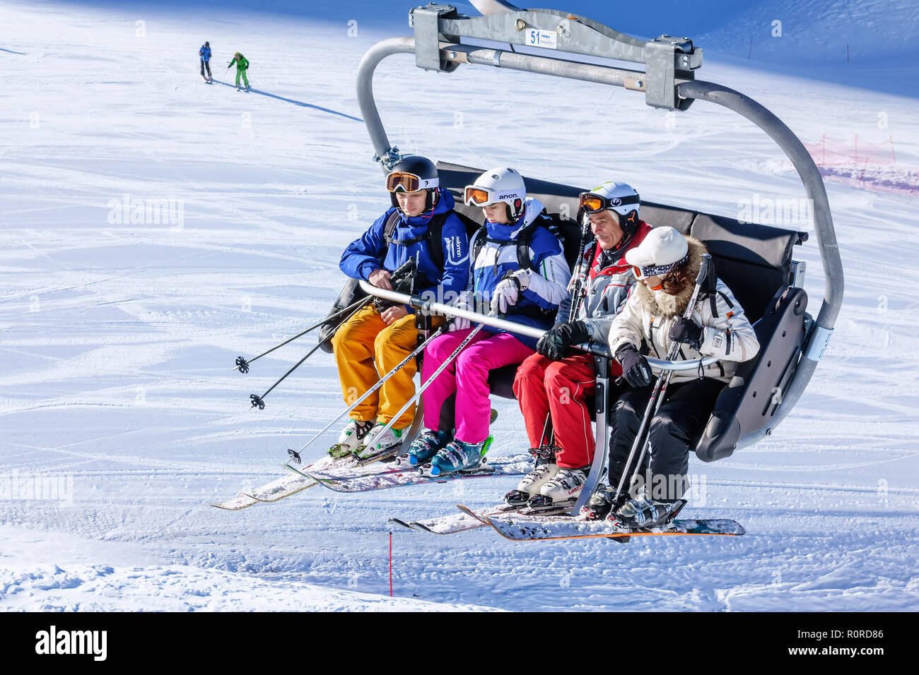 Sotschi, Russland - Januar 20, 2013: Vier Personen Fahrt auf Stuhl Skilift an sonnigen Wintertag im Kaukasus. Skipisten von Gorki Gorod Mountain Ski Stockfoto