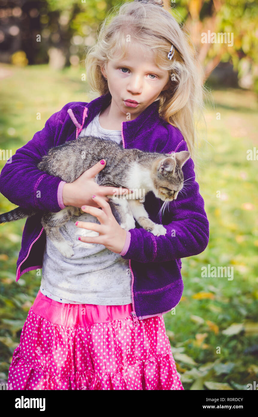 Schöne blonde Mädchen, dass eine flauschige Katze Stockfoto