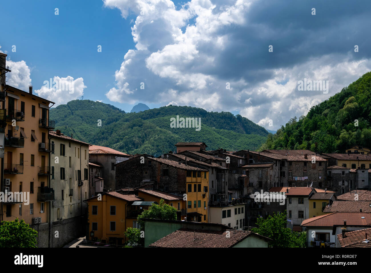 Blick auf den grünen Hügeln über Castelnuovo di Garfagnana gesehen über die Dächer Stockfoto