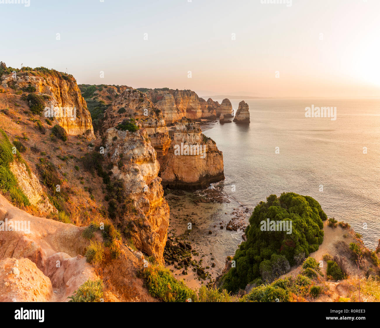 Sonnenaufgang über dem Meer, an der felsigen Küste von Sandstein, Felsformationen im Meer, Algarve, Lagos, Portugal Stockfoto