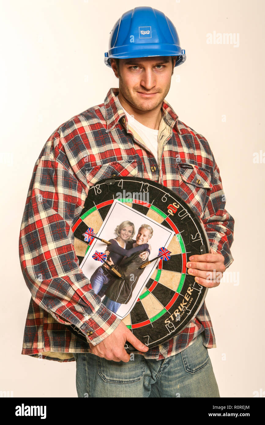 Aggressive builder Holding eine Dartscheibe mit Foto seiner Klienten auf es Stockfoto