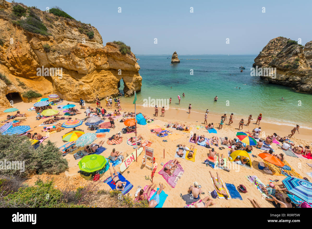 Touristen und Badegäste am Sandstrand Praia do Camilo, felsigen Küste der Algarve, Lagos, Portugal Stockfoto