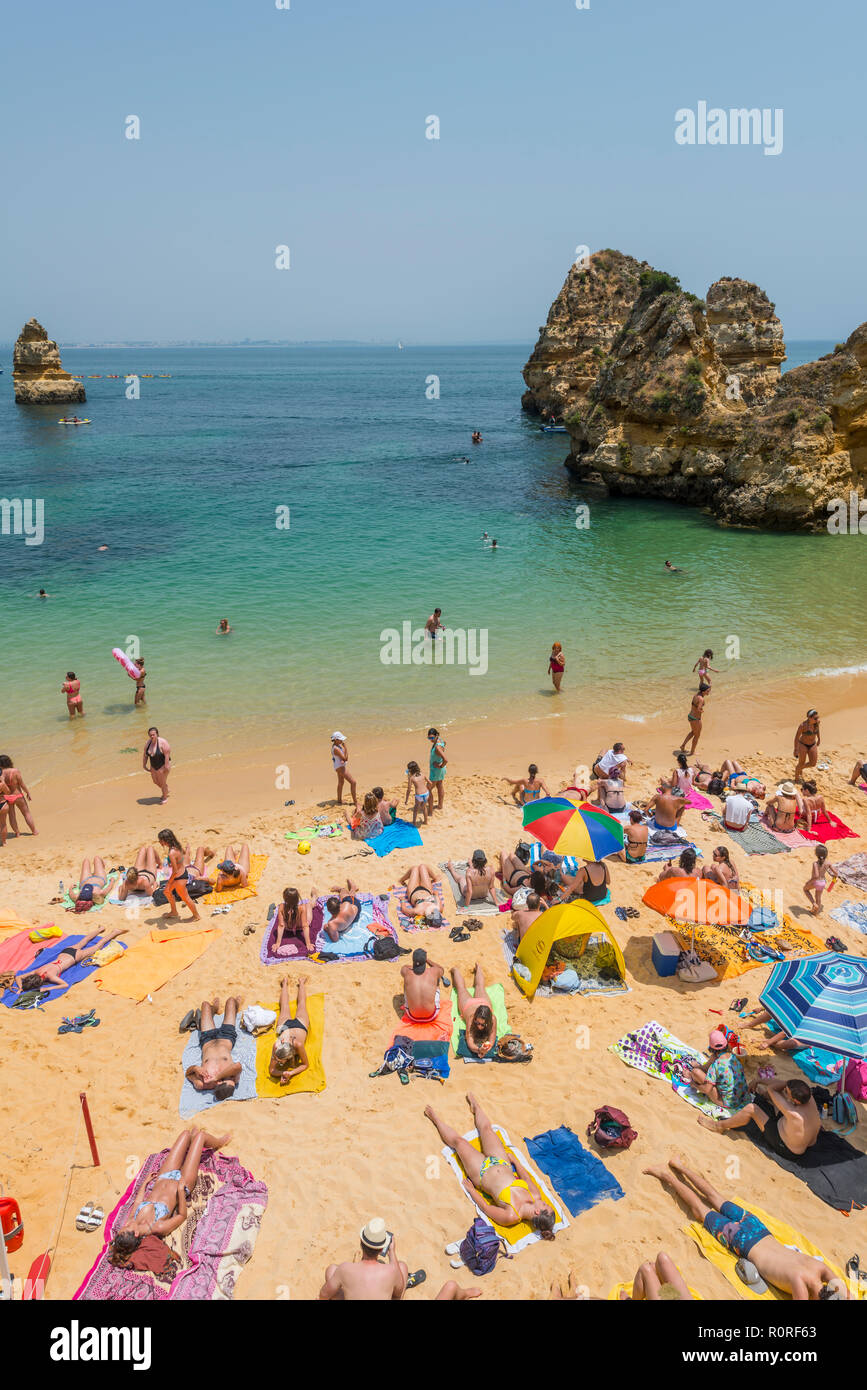 Touristen und Badegäste am Sandstrand Praia do Camilo, felsigen Küste der Algarve, Lagos, Portugal Stockfoto