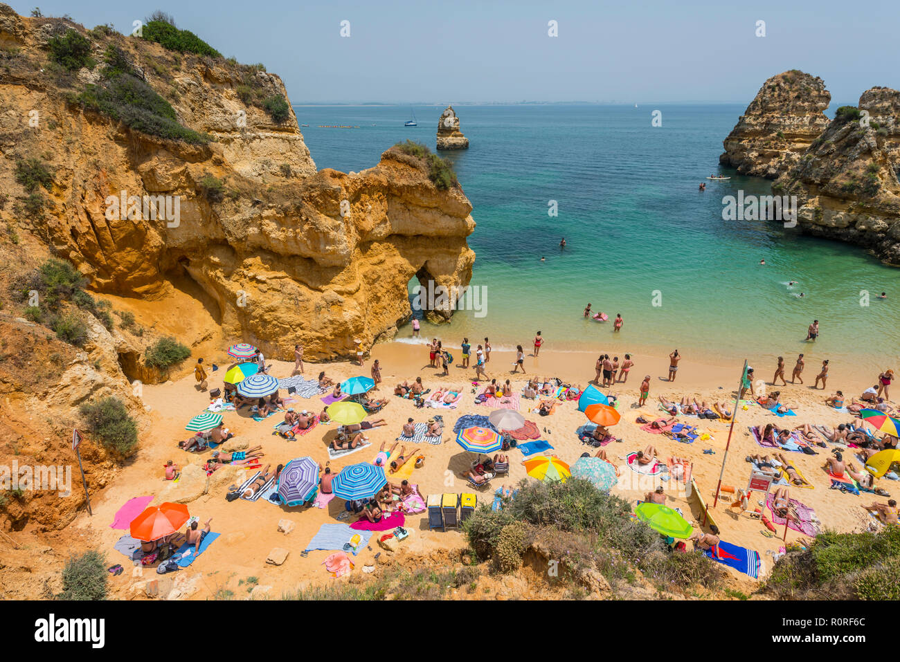 Touristen und Badegäste am Sandstrand Praia do Camilo, felsigen Küste der Algarve, Lagos, Portugal Stockfoto