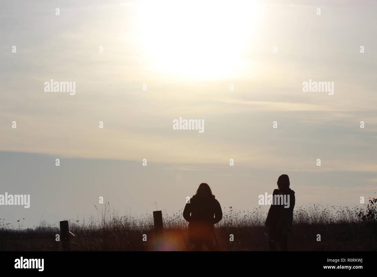 Zwei mädchen silhouette in einem Feld Stockfoto