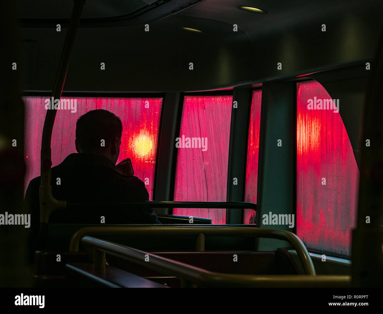 Regenwetter im Londoner Bus - die roten Ampeln werden von den nassen Fenstern eines New London Routemaster Bus durchleuchtet Stockfoto