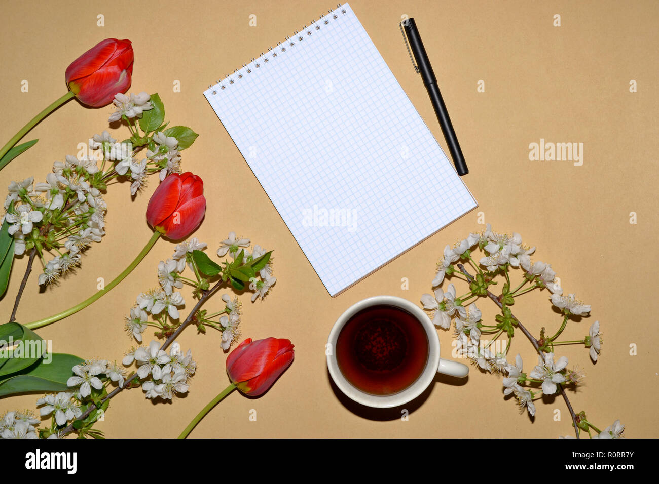 Öffnen Sie den Editor für das Schreiben mit Tulpen und weißen Blumen eingerahmt, und eine Tasse Kaffee. Stockfoto