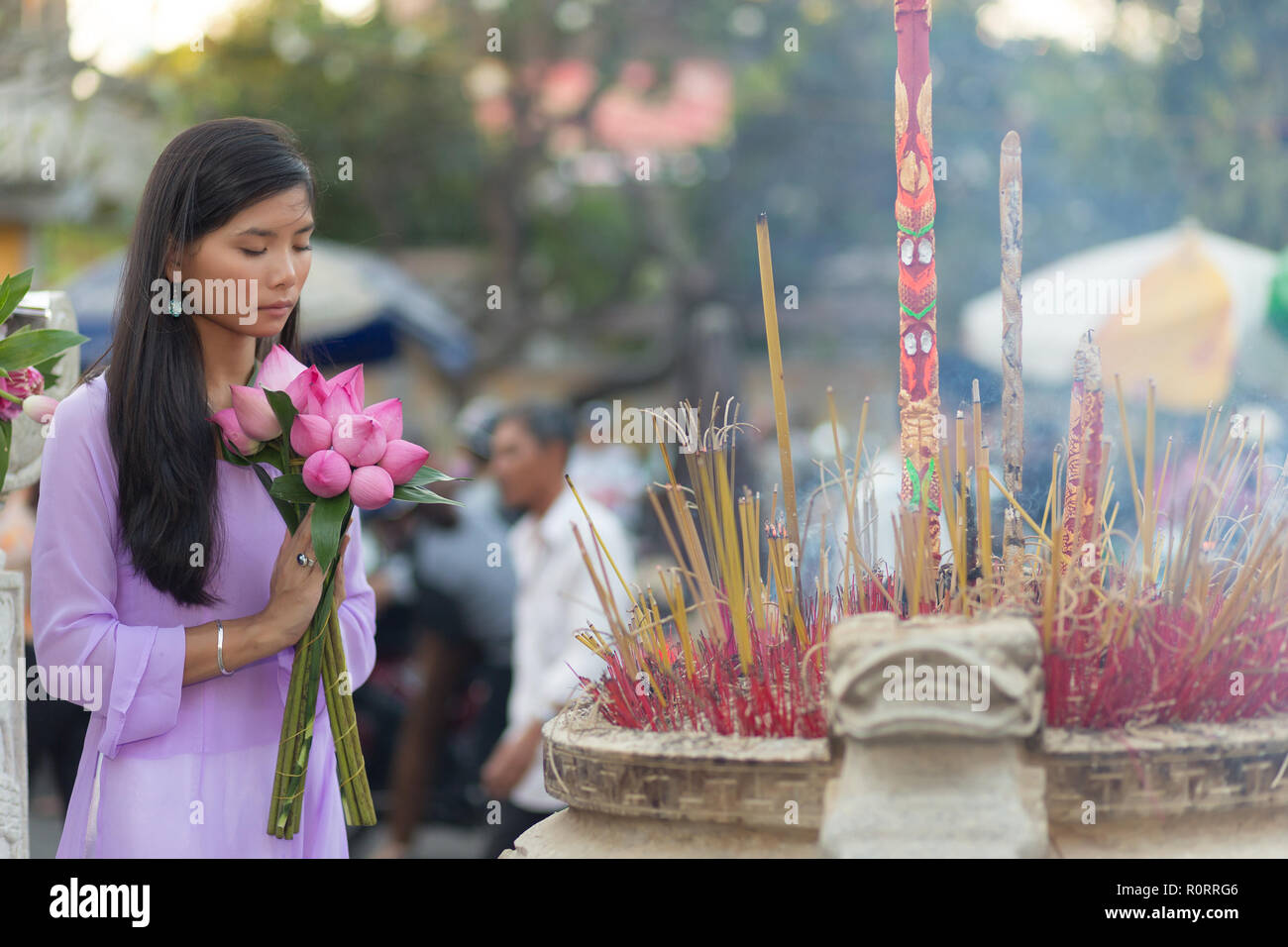 Vietnamesische Frau an Tempel holding Lotus Flower Buds Bündel beten Stockfoto