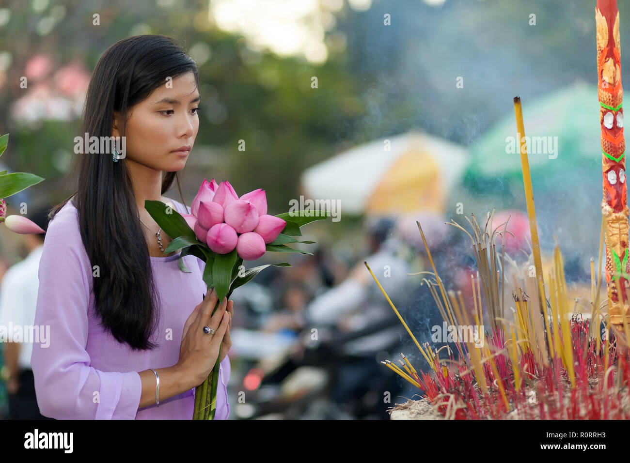 Vietnamesische buddhistische Frau an Tempel holding Lotus Flower bud Bündel beten Stockfoto
