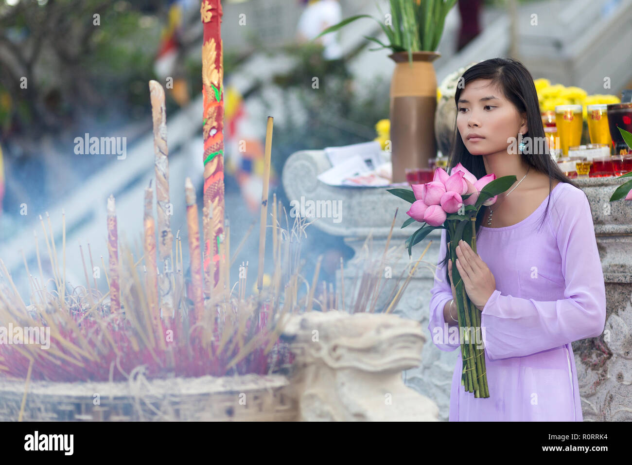 Buddhistische Frau im Tempel beten, holding Lotus Flower Buds Bündel, Vietnam Stockfoto