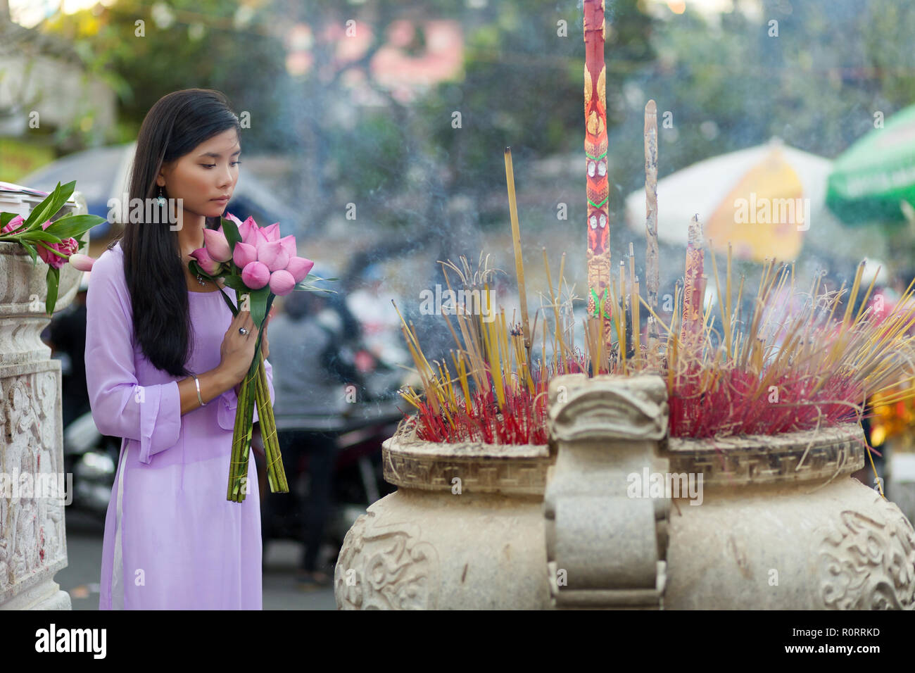 Vietnamesische buddhistische Frau im Tempel beten, holding Lotus Flower Buds Bündel, Vietnam Stockfoto