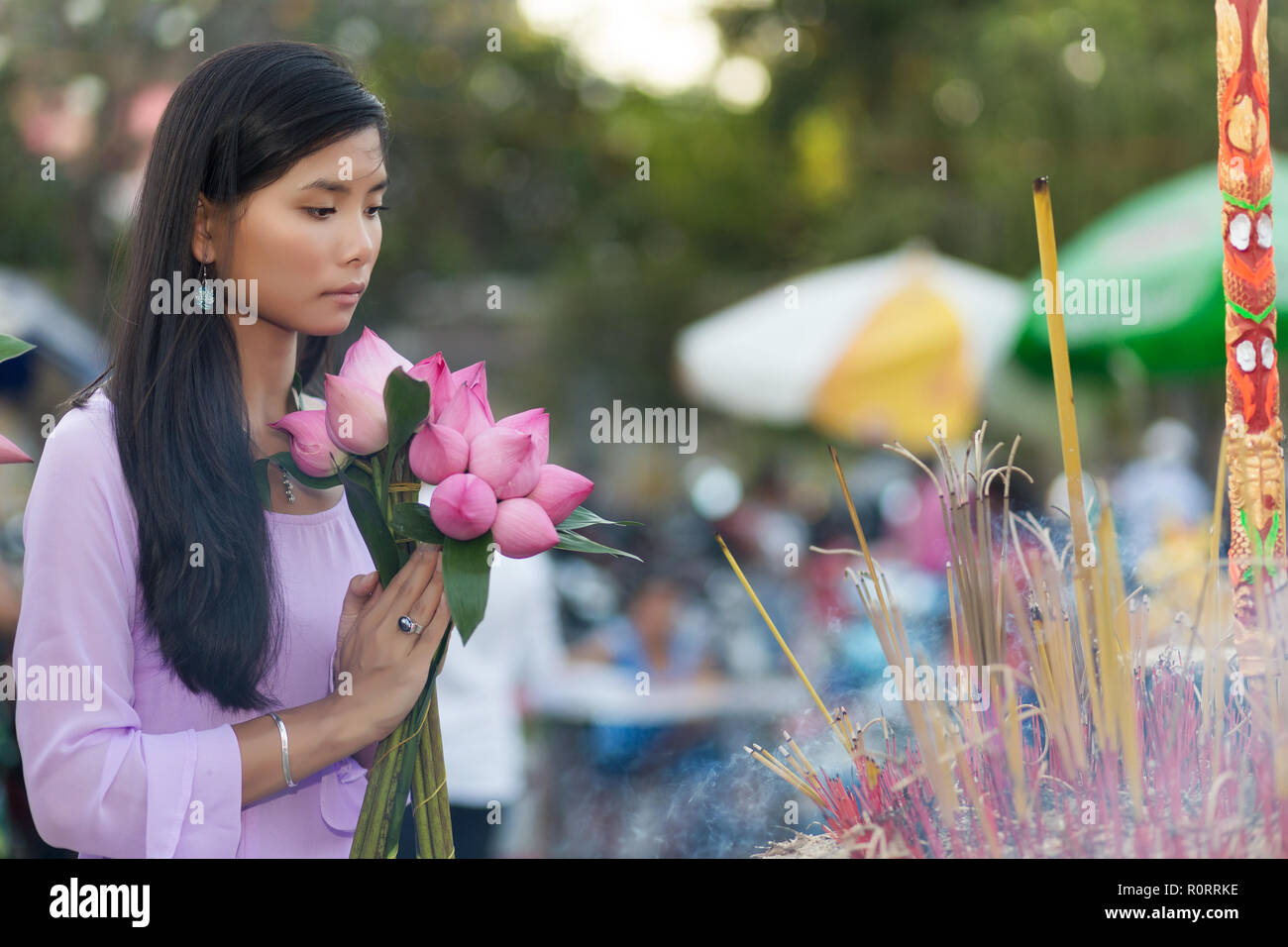 Vietnamesische Frau im Tempel beten, holding Lotus Flower Buds Bündel, Vietnam Stockfoto