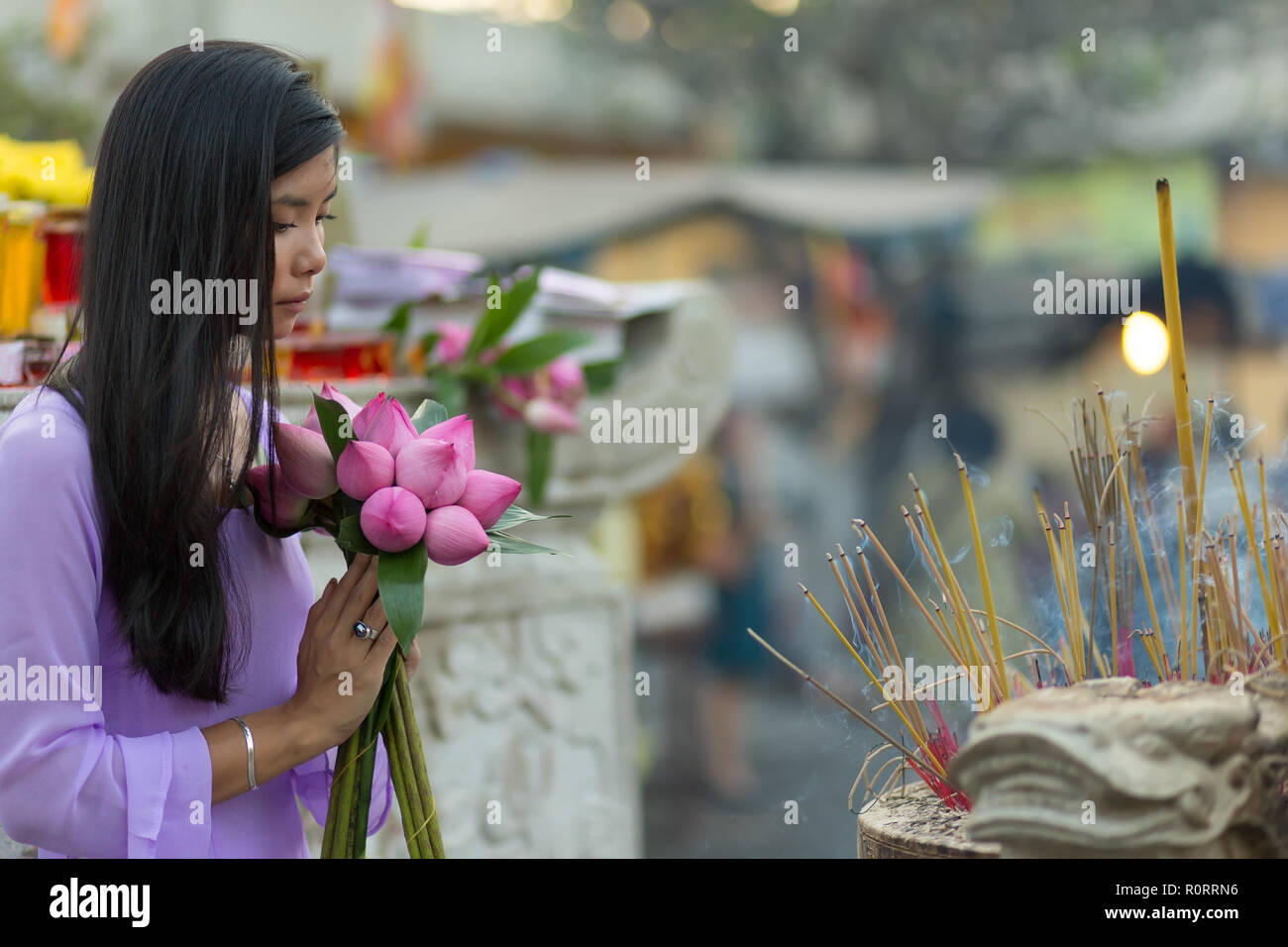 Vietnamesische Frau im Tempel beten, holding Lotus Flower Buds Bündel, Vietnam Stockfoto