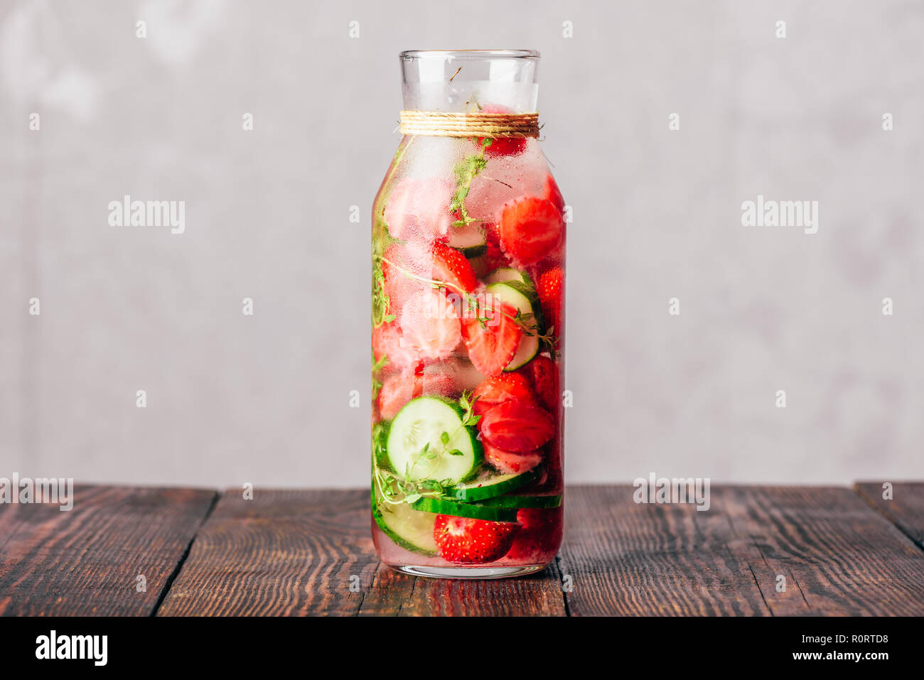 Flasche Detox Wasser mit frischen Erdbeeren, in Scheiben geschnittene Gurken und Federn von Thymian. Kopieren Sie Platz. Stockfoto