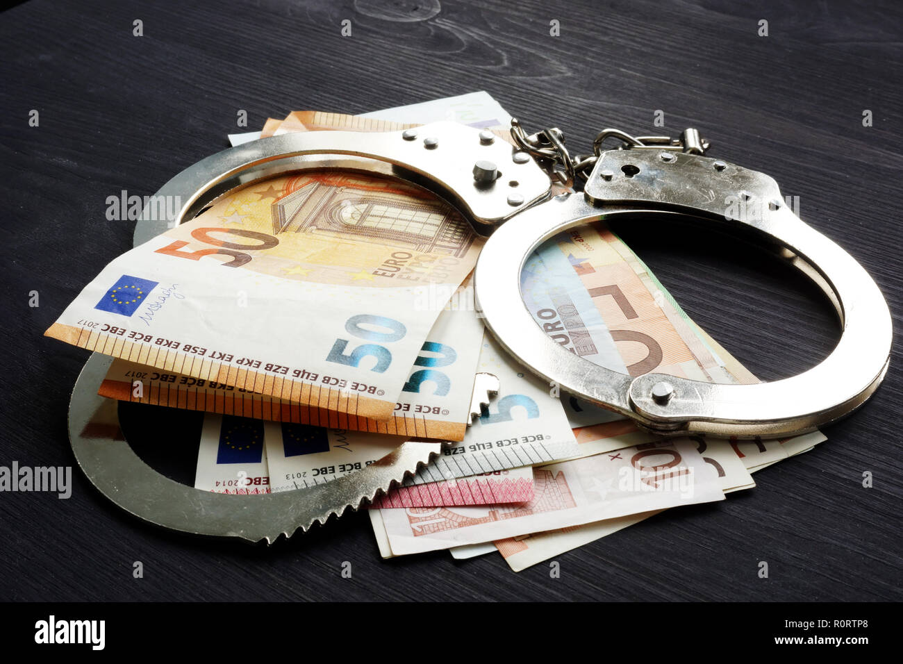 Handschellen und Euro-banknoten. Strafe oder Geldbuße im EU-Konzept. Stockfoto