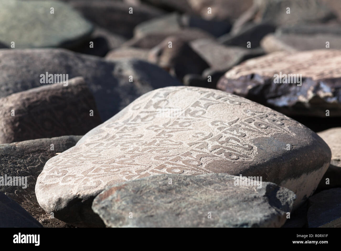 Mani Stein mit Inschrift im Bereich der Phugtal Gompa (auch bekannt als Phuktal Gompa), Zanskar, Jammu und Kaschmir, Indien Stockfoto