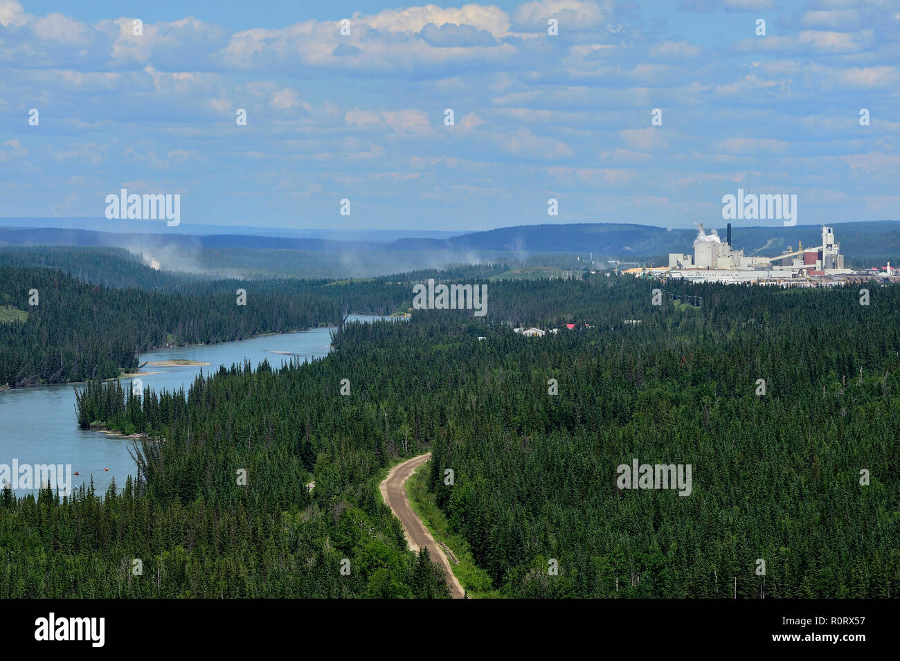Eine Landschaft Bild des Athabasca River nach Osten mit Staub aus der Forststraßen und Zellstofffabrik im Hintergrund Hinton Alberta, Kanada. Stockfoto
