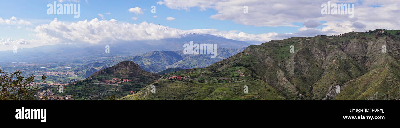 Panoramablick auf die malerische Aussicht auf Mittelmeer sizilianischen Berge Landschaft mit den schneebedeckten Gipfel des Vulkan Ätna verloren in weißen Wolken. Sicht von Castelmola in Sizilien, Italien Stockfoto