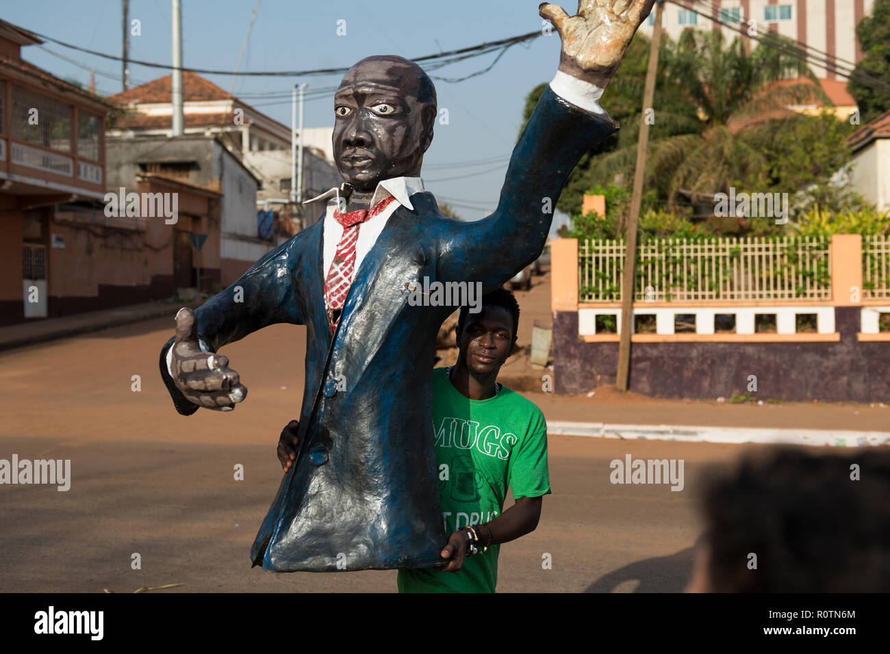 Bissau, Republik Guinea-Bissau - 12. Februar 2018: Mann hält ein Kunststoff Figur eines Polititian während der Karneval in der Stadt Stockfoto