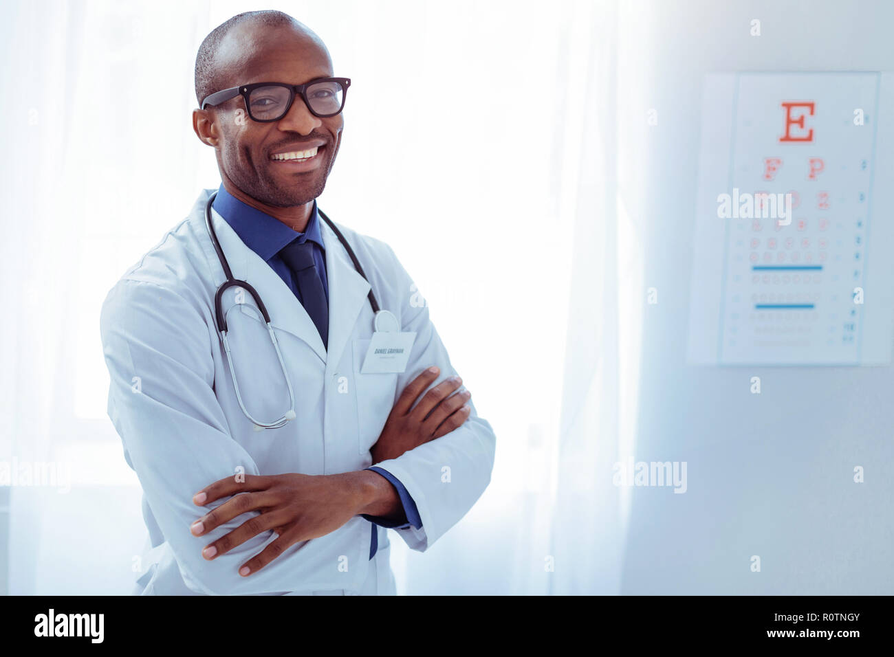 Freuen smart Arzt hohes Kreuz in seinem Krankenzimmer übergeben Stockfoto