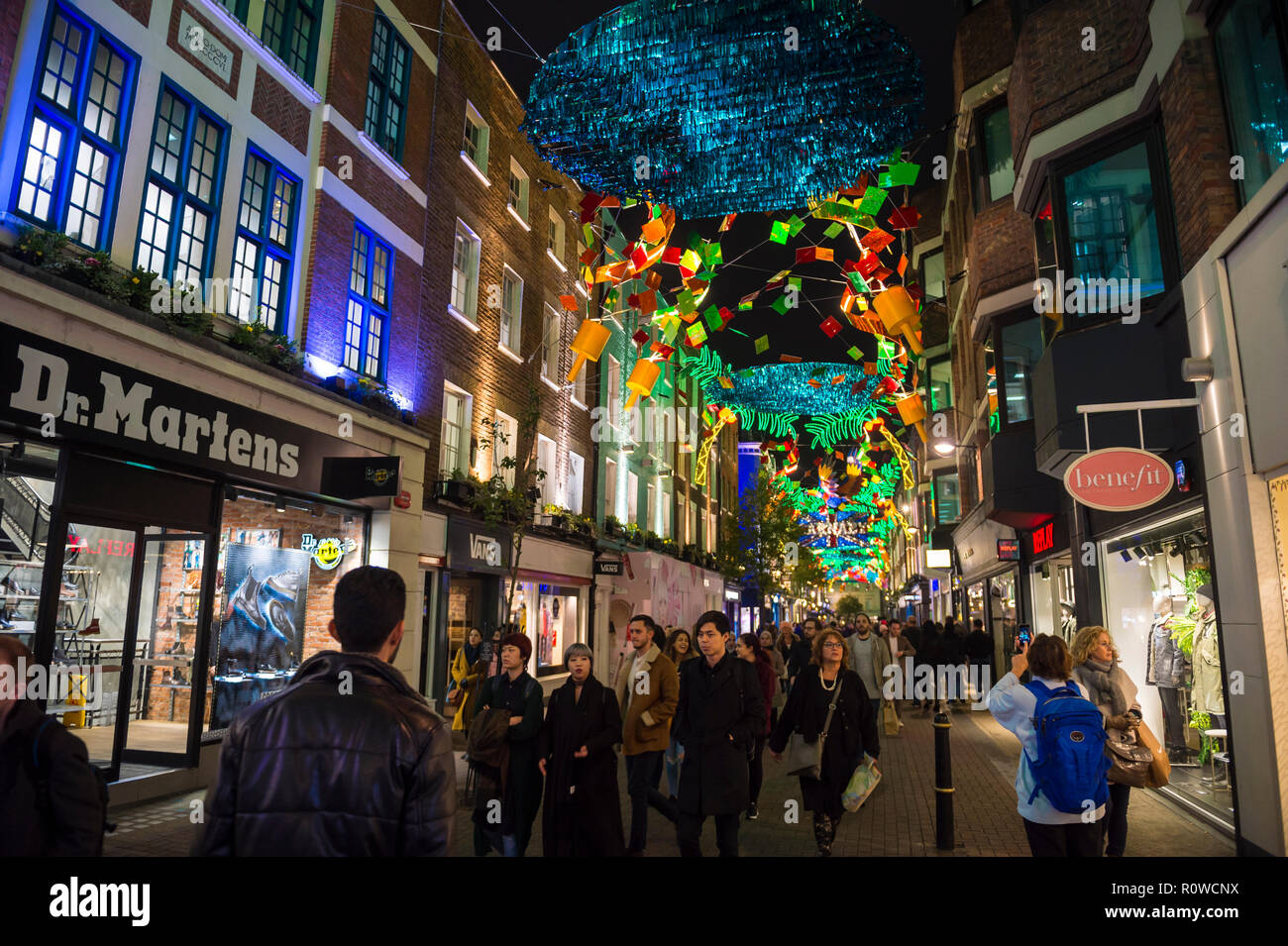 LONDON - ca. Dezember 2017: vorweihnachtlichen Menschenmassen unter Karneval pass themenbezogene Weihnachten Zeichen in der Fußgängerzone Einkaufsviertel von Carnaby Street. Stockfoto